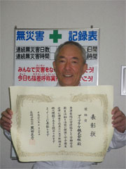 [Mr. Yamada, head of General Affairs Dept., smiling with a certificate of commendation]
